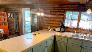 Una cocina con detalles de madera, un fregadero, un tostador y una cafetera.