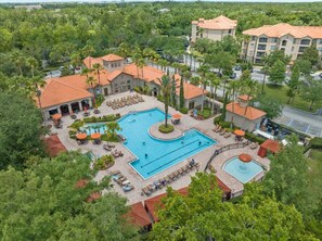 A resort with a central swimming pool, lounge areas, and a landscaped courtyard. - Near Disney w/ pool-3BR/2BA-Spacious & Cozy Condo (Davenport)