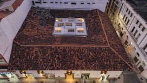 A building with a tiled roof, a central courtyard, and a street-level entrance with shops.