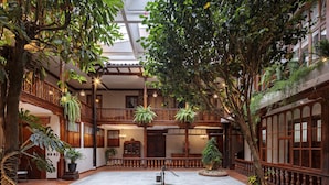 A spacious atrium with a high ceiling, multiple levels, and lush greenery.