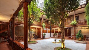 A spacious atrium with a central fountain, wooden railings, and multiple levels with balconies.