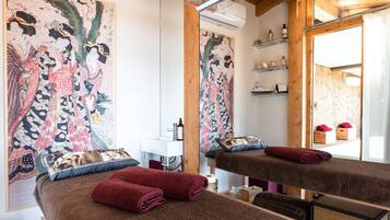 Ein Zimmer mit einem Bett, einem Spiegel, einem Waschbecken und einem großen Gemälde an der Wand.