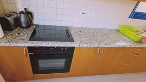 Une cuisine équipée d’un four encastré, d’une plaque de cuisson et d’un grille-pain.