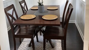 A dining area with a rectangular table, six chairs, and a vase with white flowers. - Comfy and Cozy Centrally located in Houston!! (Houston)