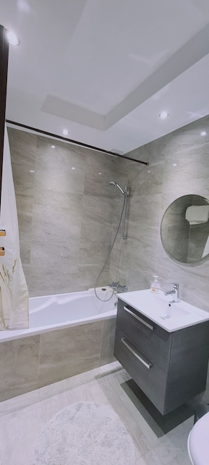A modern bathroom with a bathtub, shower, and vanity. - STAY Downtown Retreat (Agios Athanasios)