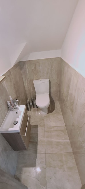 A bathroom with a toilet, sink, and toiletries. - STAY Downtown Retreat (Agios Athanasios)