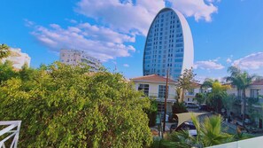 A modern building with a curved facade, surrounded by lush greenery and other residential buildings. - STAY Downtown Retreat (Agios Athanasios)