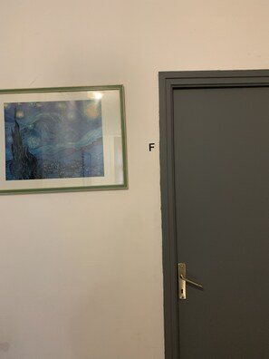 A door with a lock and a framed painting of a night sky with stars and a tree on the wall. - Small room near Belgium (Halluin)