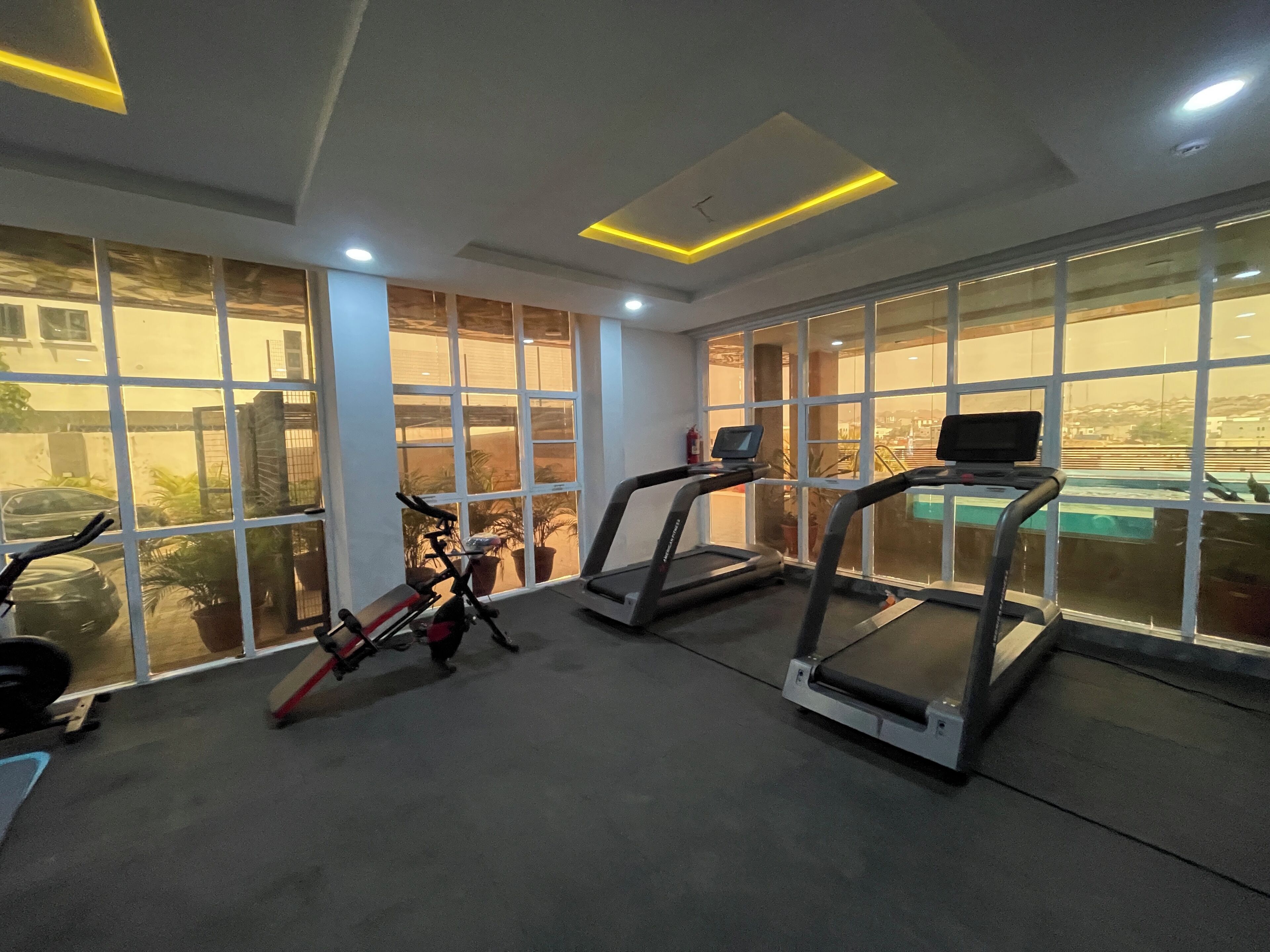 A gym with treadmills, a stationary bike, and a weight bench.