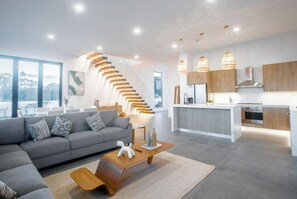 Relax in this stylish living space with a sofa, coffee table, and staircase leading to an upper level.