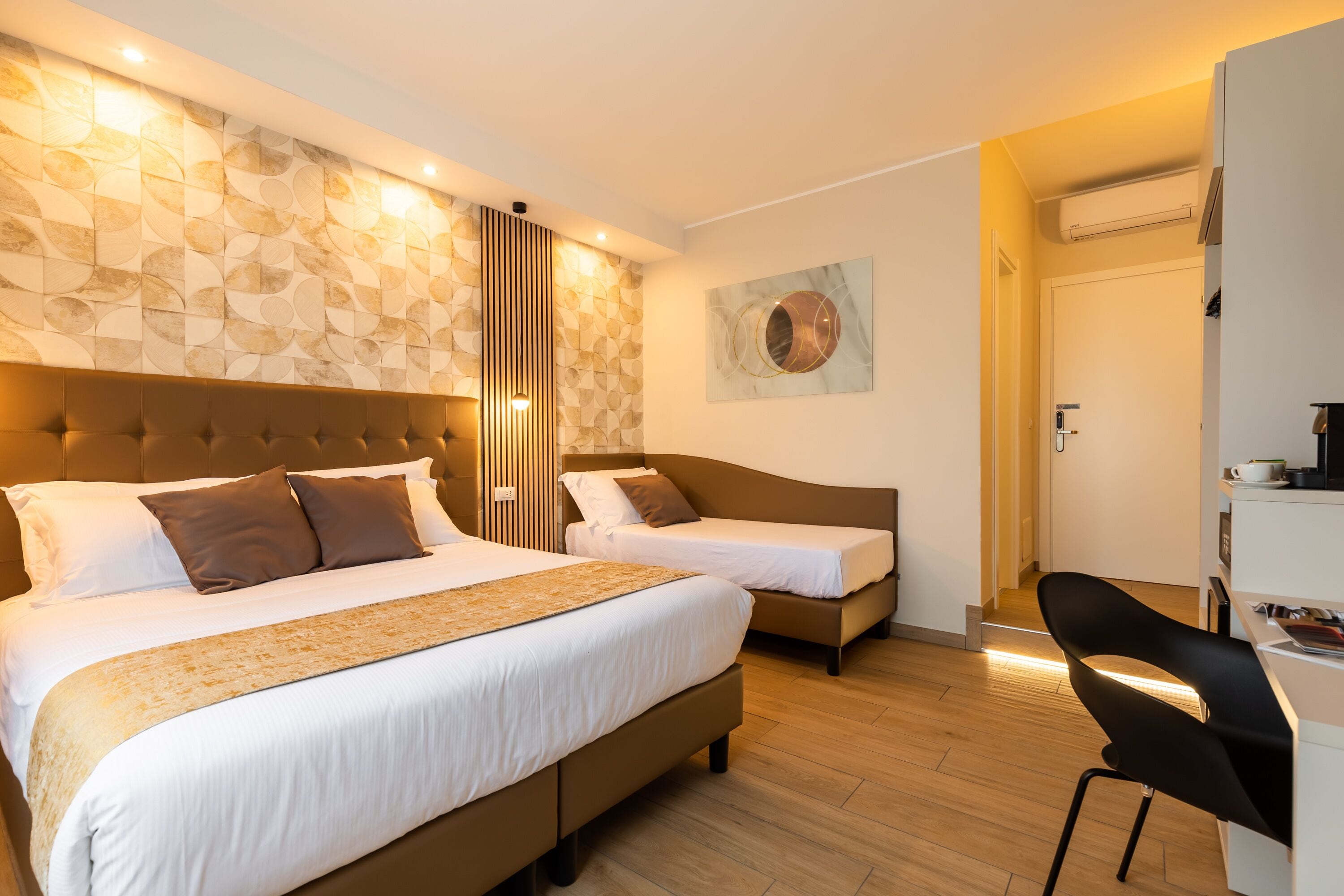 Una habitación de hotel con dos camas, un escritorio y una silla.