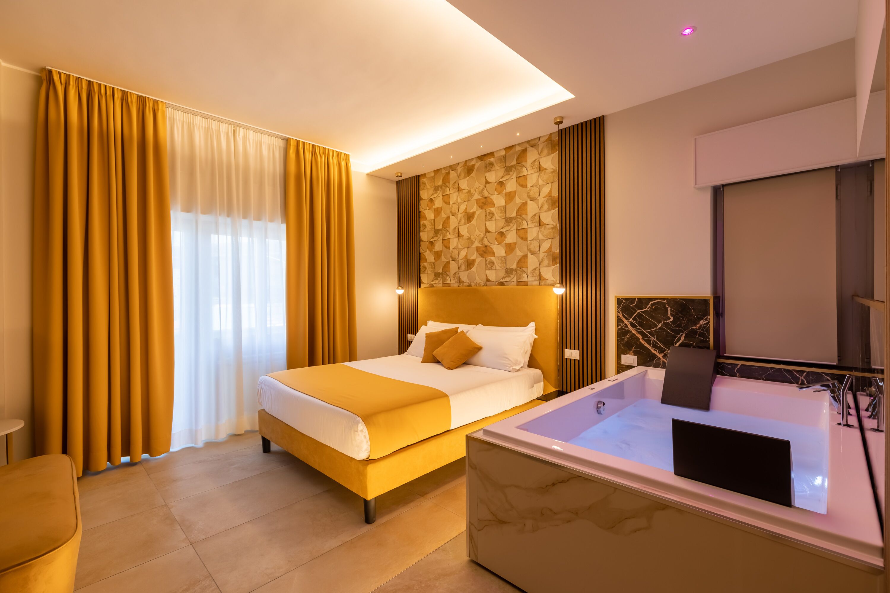 A hotel room with a large bed, a separate bathtub, and a view of the city.