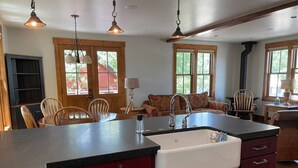 A kitchen with a central island, a sink, and wooden cabinets. There are chairs and a sofa in the background. - In the Town of Crested Butte! Near parks, trails, shops & restaurants (Crested Butte)