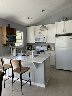Enjoy cooking in this kitchen with a central island, microwave, and stainless steel range hood.