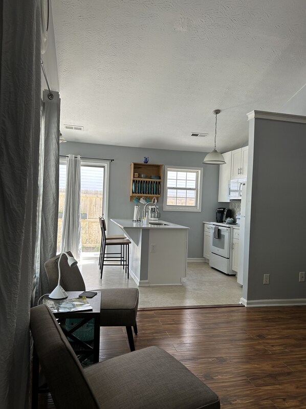 Enjoy meals in the kitchen with a central island and oven, adjacent to a dining area with a table and chairs.