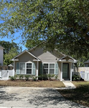 Stroll up to this charming home with a front porch, surrounded by a white picket fence and a shaded yard.