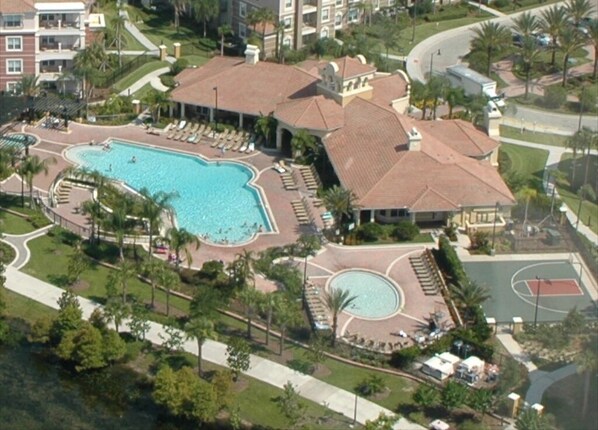 An aerial view of a resort with a large swimming pool, sun loungers, a basketball court, and a tennis court. - Beautiful 3 bedrooms Condo at Vista Cay with lake view. 
Refurbished July 2024 (Orlando)