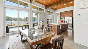 A modern kitchen with a central island, large windows, and a view of a lake.