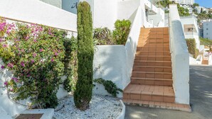 A white building with a staircase leading to a higher level. - V021 - Neptuno (Roses)
