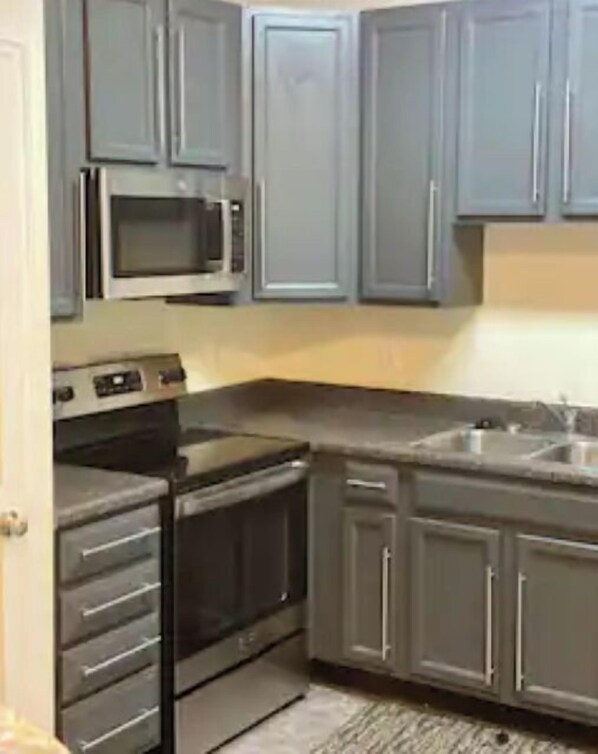 Kitchen area with microwave, stove, and sink.