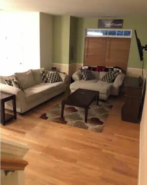 Relax in this inviting living room with a sofa set, coffee table, and patterned rug.