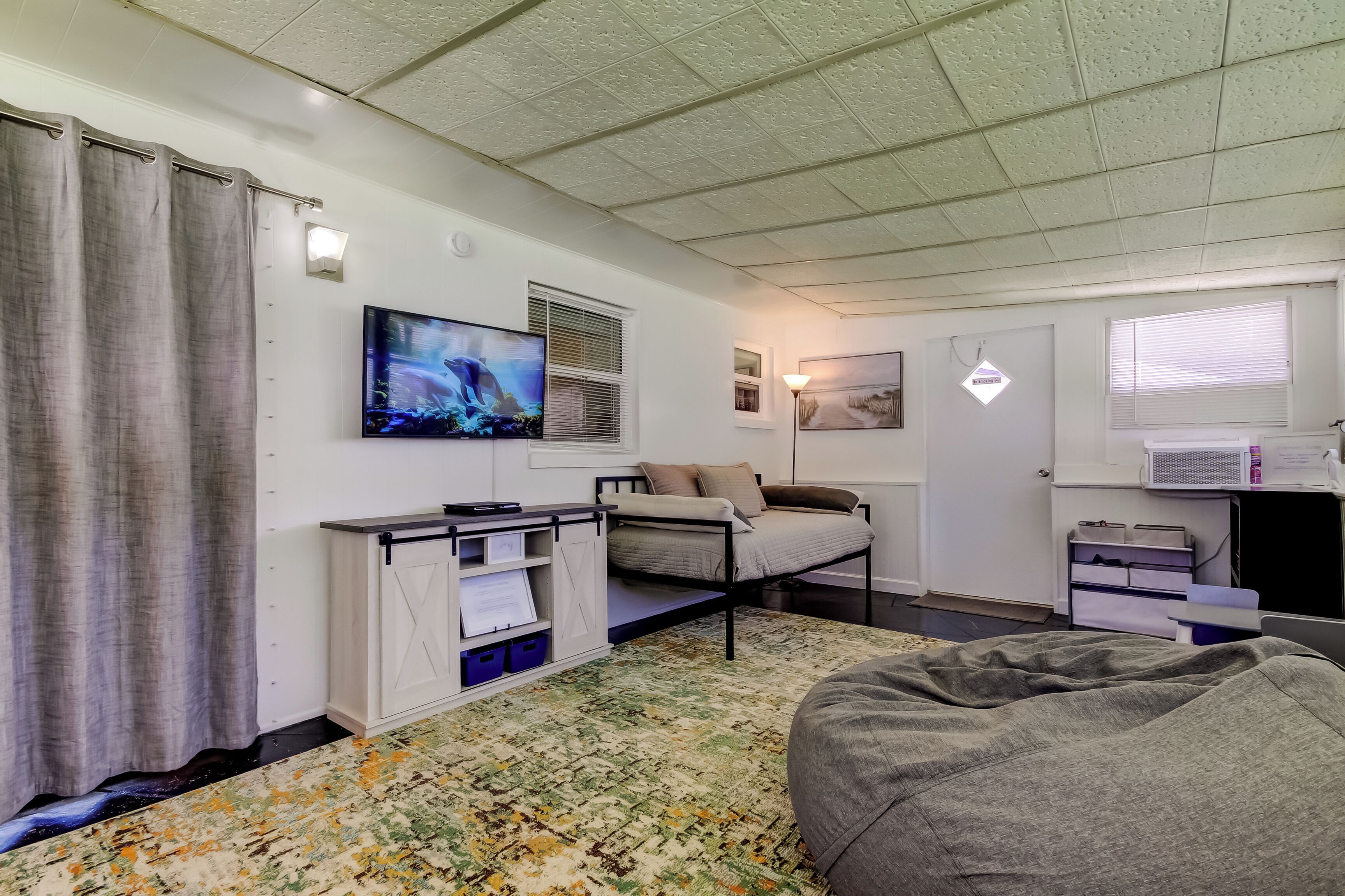 A bedroom with a bed, a TV, a desk, and a wardrobe.