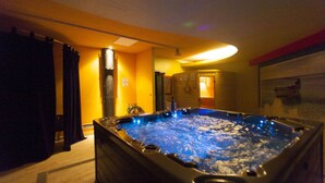 Ein Whirlpool in einem Raum mit Teppichboden, einer Tür und einer Wandleuchte.