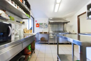 A modern kitchen with stainless steel appliances, a large range hood, and a clean, tiled floor. - Villa Vedorna, pool, whrilpool, sauna, t. tennis, poker tables, playground,.. (Pomer)