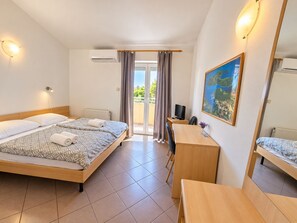 A hotel room with a bed, desk, chair, and a large window. - Villa Vedorna, pool, whrilpool, sauna, t. tennis, poker tables, playground,.. (Pomer)