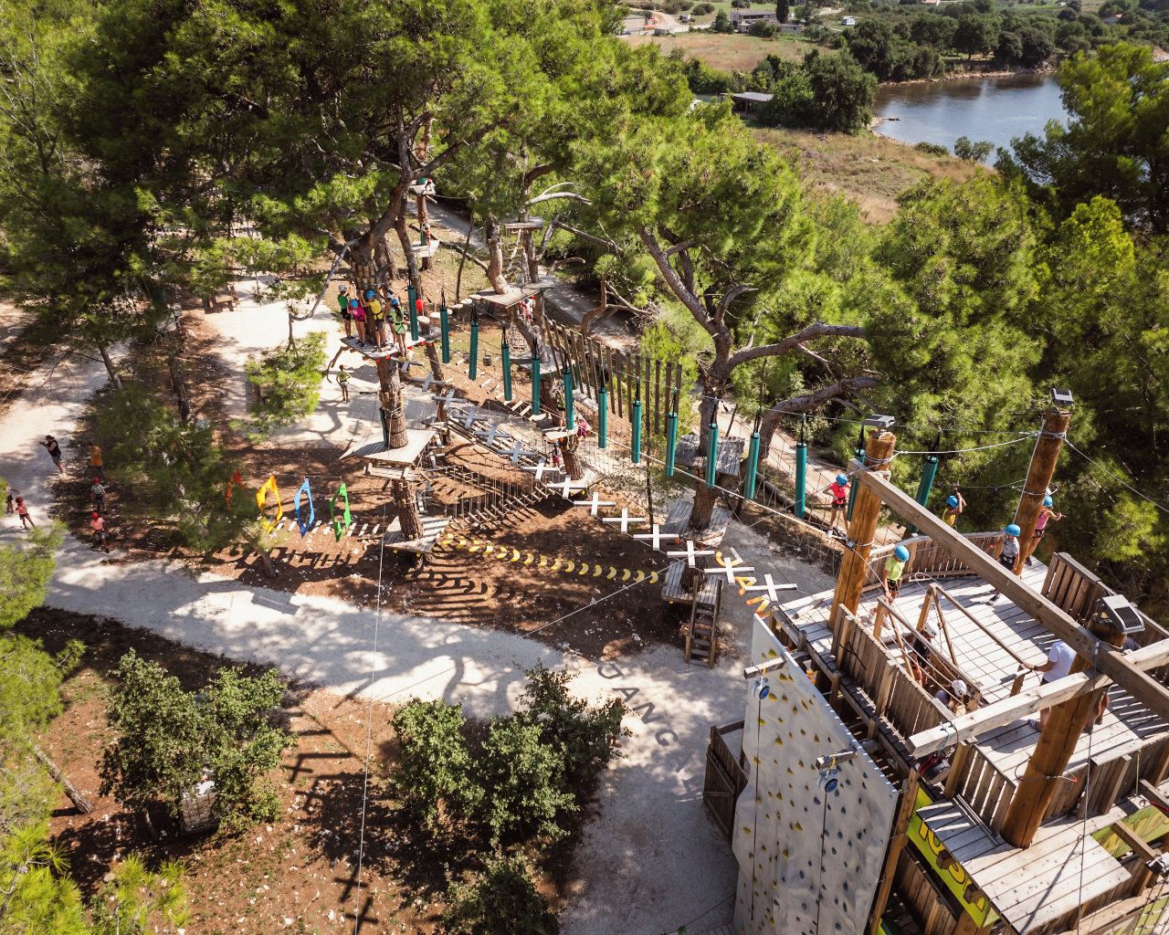 An aerial view of a treehouse playground with multiple levels and rope bridges.
