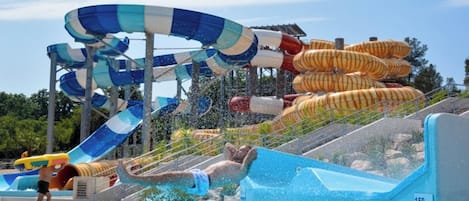 A water park with a large water slide, a pool, and a lifeguard tower.
