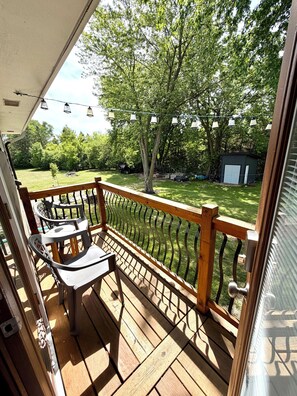 A wooden deck with a railing, a small table, and chairs. - Beautiful 2 Bedroom Duplex (Fond du Lac)