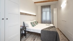 A bedroom with a bed, bedside table, and a chair.