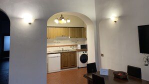 A kitchen with wooden cabinets, a microwave, and a washing machine.