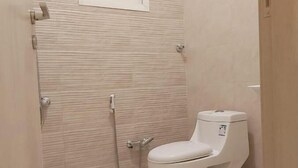 Ein Badezimmer mit Toilette, Dusche und Fenster.