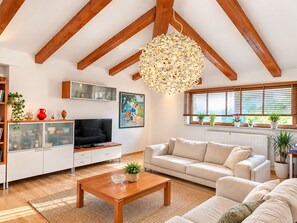 A modern living room with a wooden ceiling, a television, a sofa, a coffee table, and a large decorative light fixture. - Luxury apartment MARIN, Pomer - Istria (Pomer)