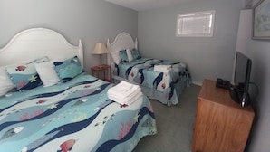 Un dormitorio con dos camas, televisión y ventana.