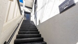 Eine Treppe führt zu einer Tür, an der ein Schild den Standort der Penthouses im Hauptgebäude angibt.