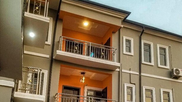 Un edificio a più piani con balconi, un lampadario centrale e una finestra con condizionatore.