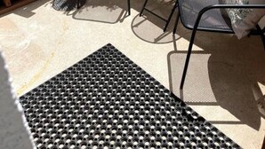 A patio area with a metal chair and a small round table, a white wall, and a staircase. - Quick walk to trails, Close to shops, restaurants (Sedona)