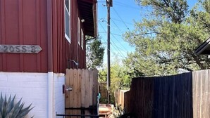 A narrow gravel path leading to a red and white building with a wooden fence on one side. - Quick walk to trails, Close to shops, restaurants (Sedona)