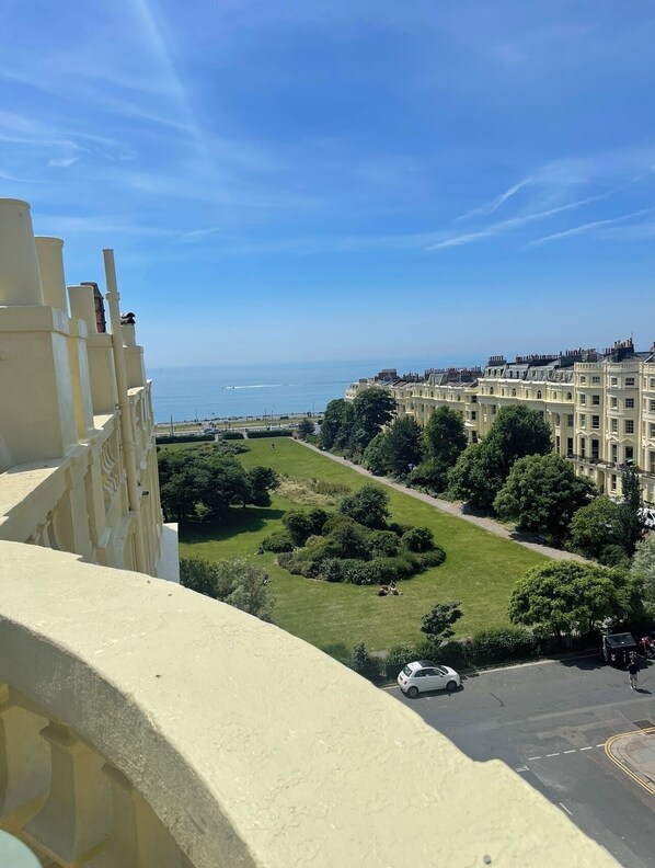 Enjoy a serene view from the balcony overlooking the beautifully manicured courtyard with lush trees and a tranquil atmosphere.