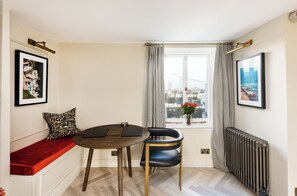 Enjoy a city view from the window, accompanied by a round table and a single chair.