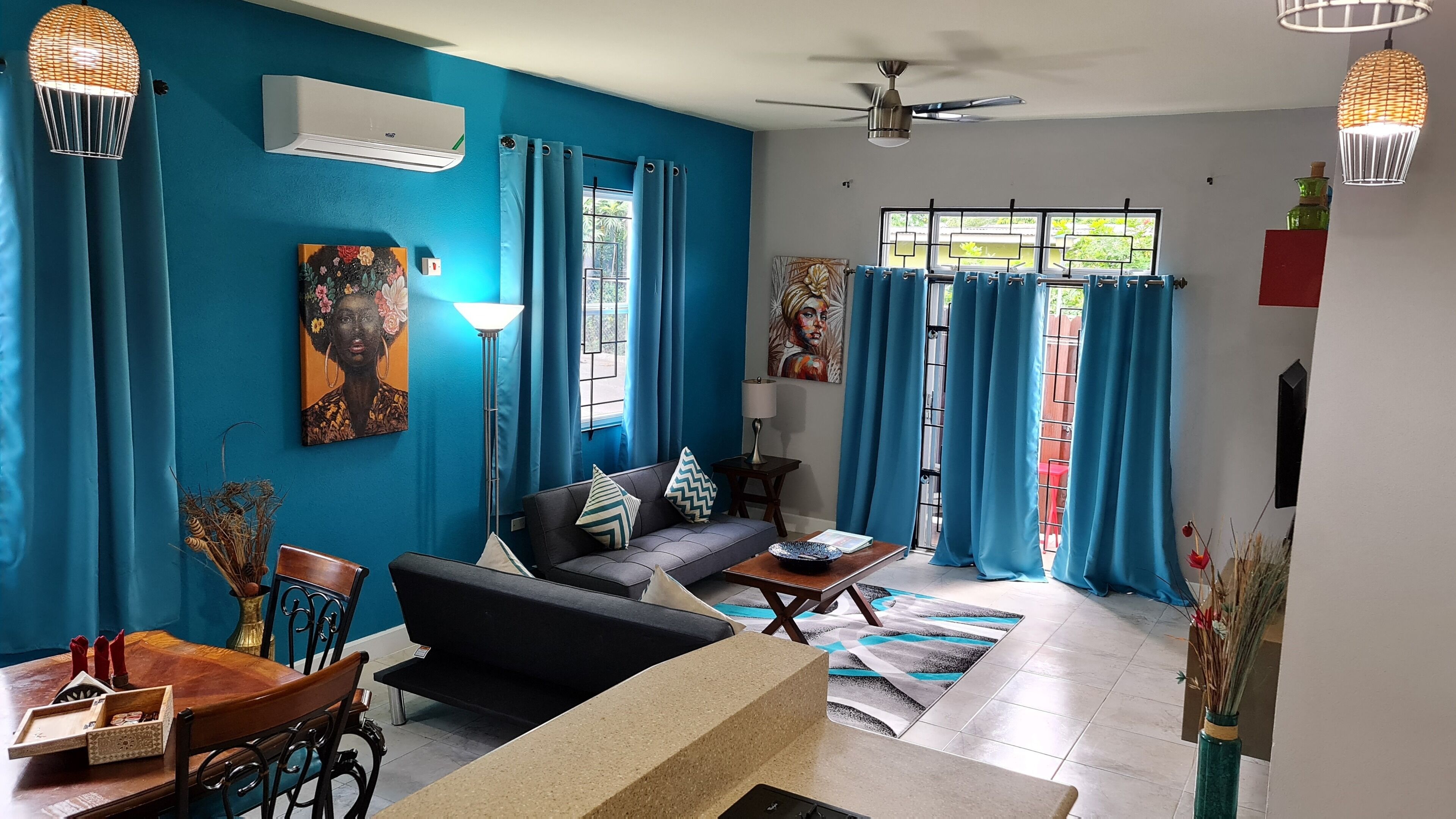 A living room with a blue wall, a sofa, a coffee table, and a dining area with chairs and a table.