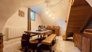 Un comedor acogedor con una mesa de madera, bancos y un tapete de cuero de vaca.
