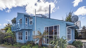 Ein blaues Haus mit einem einzigartigen architektonischen Design, darunter eine Wendeltreppe und große Fenster.