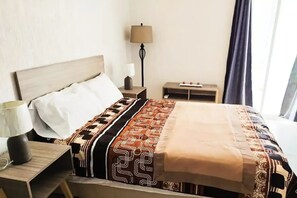 Cozy retreat with a bed, nightstand, and table, perfect for a restful stay.