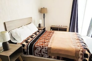 Cozy retreat with a bed, nightstand, and table, perfect for a restful stay.