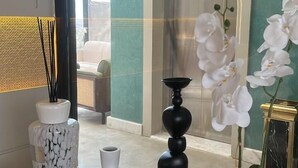 Una mesa de madera con jarrones decorativos y una planta de orquídea.