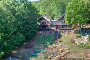 Escape to a serene forest retreat with a cozy cabin featuring a spacious porch and lush garden surroundings.